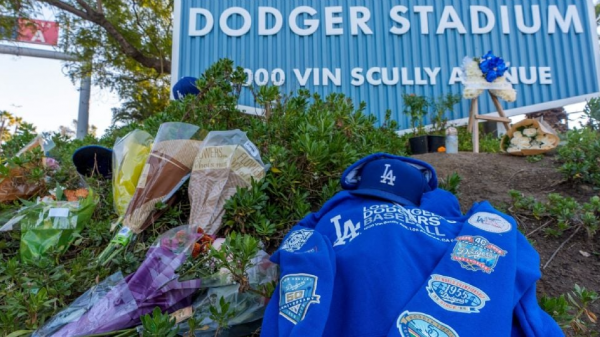 Aficionados llevan ofrendas para Fernando Valenzuela a Dodger Stadium, que se ilumina en honor al mexicano tras su muerte